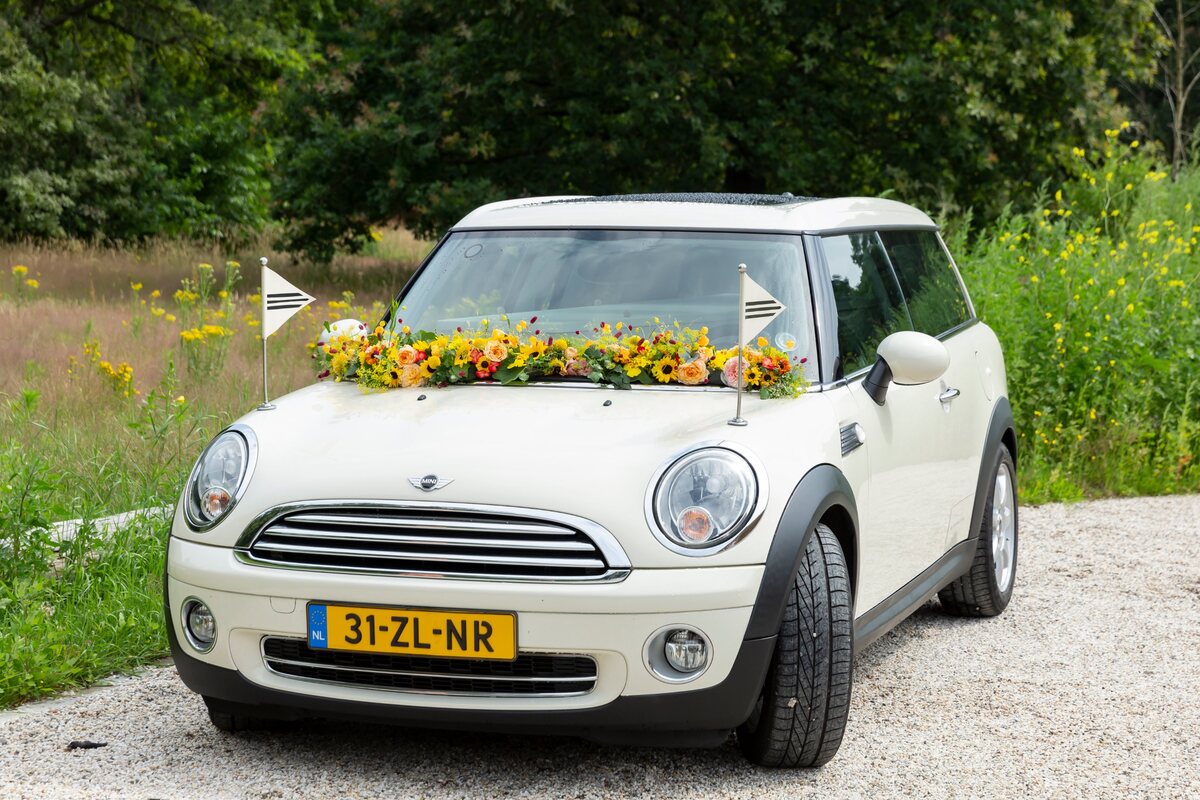 De Minirouwauto met een bloemstuk op de motorkap